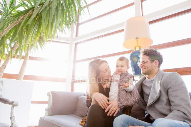 Веселий сім'я з дитиною, сидячи на дивані — стокове фото