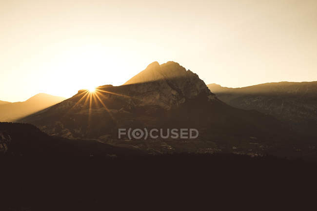 Mountains in backlit during sunset in clear sky. — Stock Photo