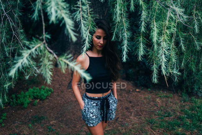 Brunette pensive woman posing in fir branches — Stock Photo