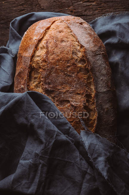 Rustic loaf of artisan bread wrapped in canvas — Stock Photo