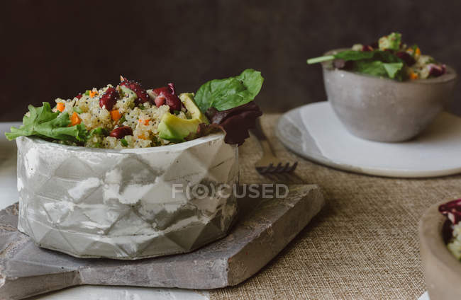Cuencos de ensalada de quinua y frijoles rojos en la mesa - foto de stock