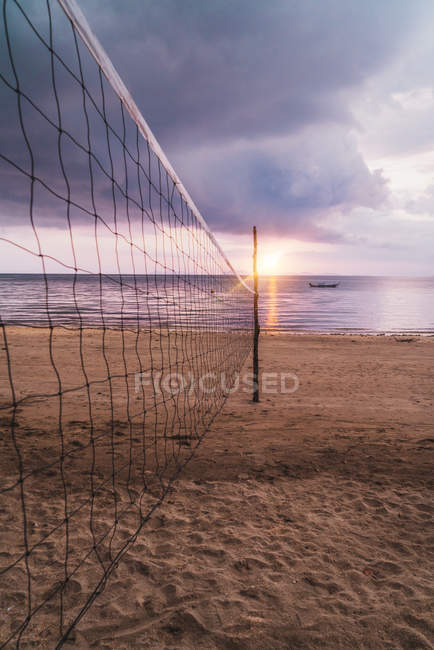Volleyball net at sunset sand beach — Stock Photo
