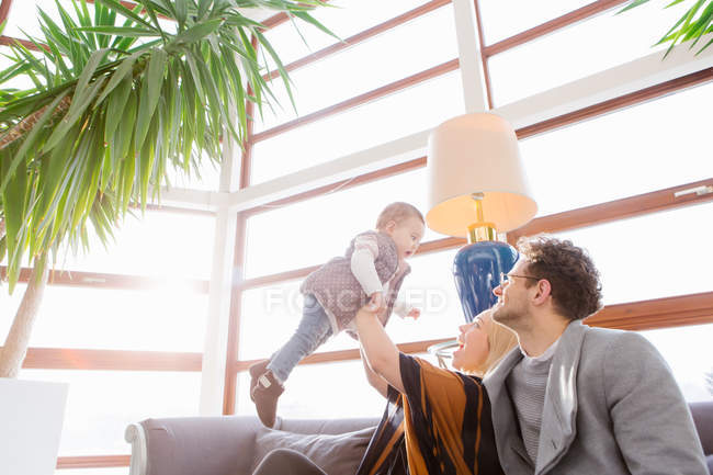 Fröhliche Familie spielt mit Kind auf Couch — Stockfoto