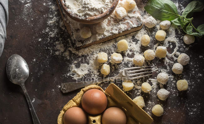 Directly above view of raw gnocchi and ingredients on kitchen counter — Stock Photo