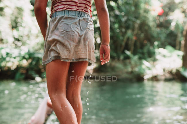 Vue arrière de la culture enfant humide debout au petit étang dans la forêt . — Photo de stock