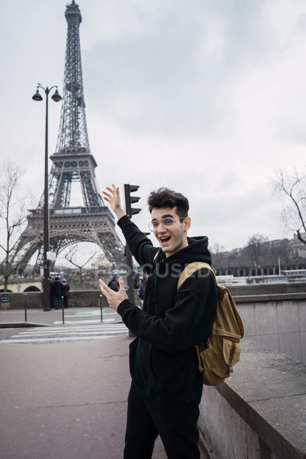 Jovem sorridente gesticulando para a Torre Eiffel . — Fotografia de Stock