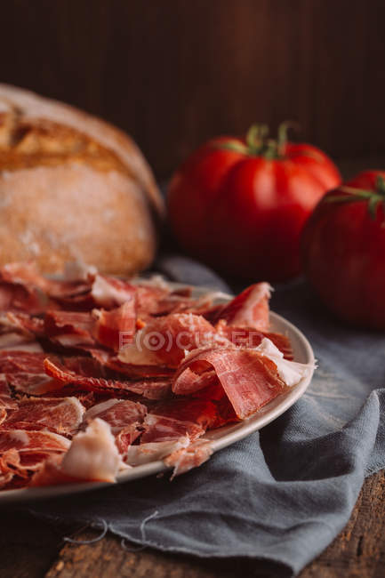 Spanischer Schinken mit Tomaten am Brot auf Leinwand — Stockfoto
