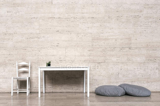 Minimalism furniture and cushions against beige wall — Stock Photo