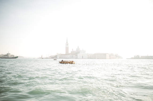 Small boat sailing in blue water of Venice channel. — Stock Photo