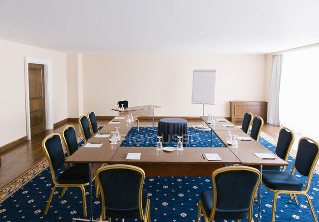 Сучасна презентаційна кімната з дошкою для білизни та столом зі стільцями — стокове фото