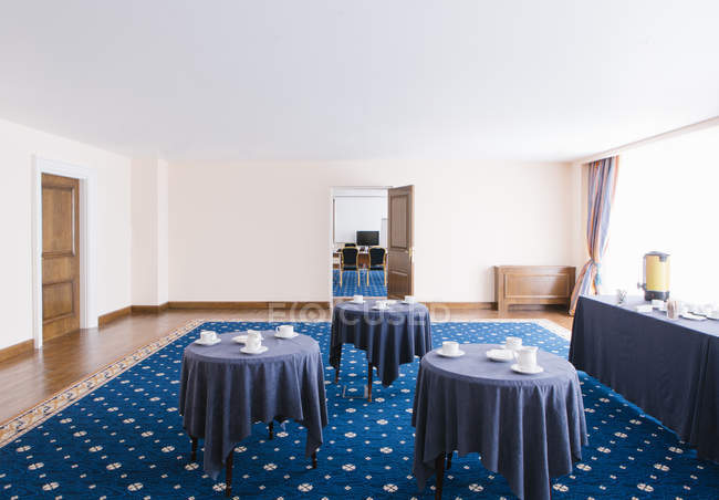 Interno blu colorato di grande sala con tavoli e tazze servite . — Foto stock