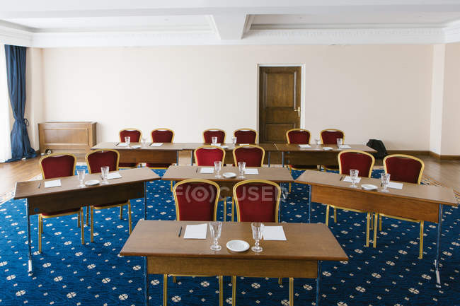 Interior da sala de conferências com mesas e cadeiras vermelhas . — Fotografia de Stock