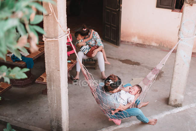 ЛАОС, ЛУАНГ ПБАНГ: Матери с детьми сидят во дворе . — стоковое фото