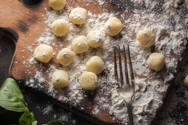 Gnocchis crus dans la farine à la fourchette sur les planches — Photo de stock