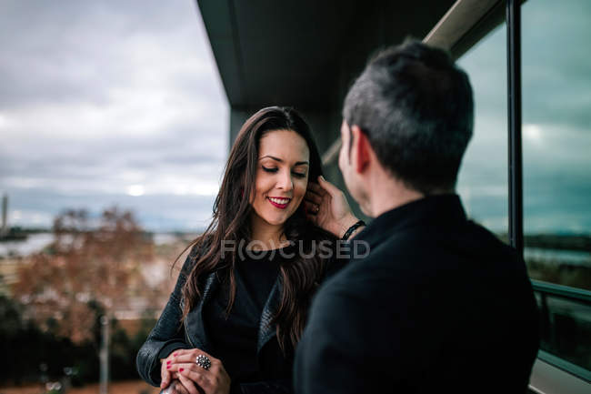 Rear view of man touching hair of smiling brunette woman at balcony — unrecognizable, flirting - Stock Photo | #190042698 Rear view of man touching hair of smiling brunette woman at balcony — unrecognizable, flirting - Stock Photo | #190042698