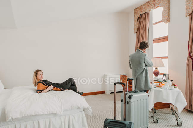 Giovane coppia rilassante dopo il viaggio in camera d'albergo — Foto stock