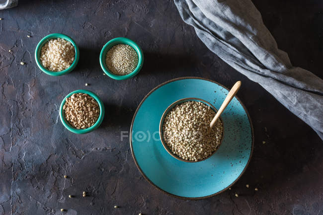 Diretamente acima vista de tigelas cerâmicas cheias de cereais e flocos de trigo na mesa — Fotografia de Stock