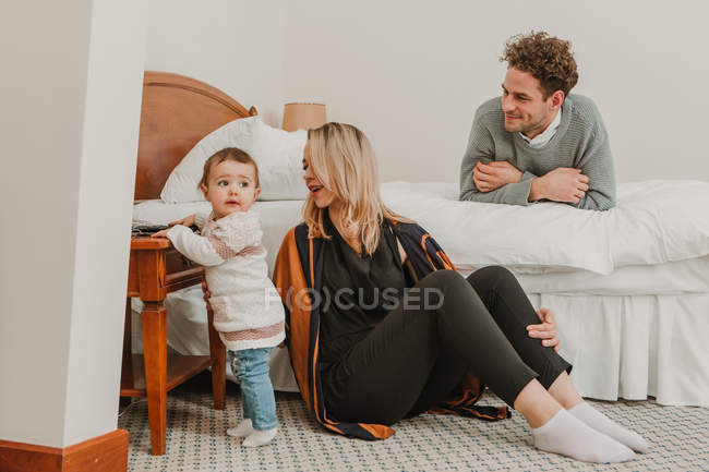 Весела пара дивиться на дитину ліжком — стокове фото