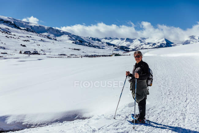 Man posing with trekking sticks in snowy meadow — Stock Photo