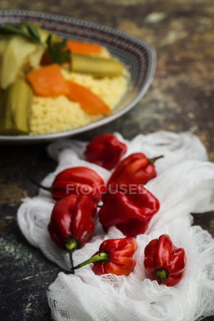 Close up view of fresh red peppers on white fabric at table — Stock Photo