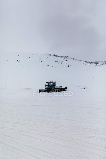 Snow removal machine working on snow meadow — Stock Photo