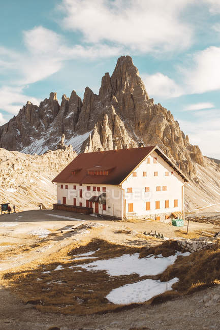 Casa rural grande no fundo de picos em dia ensolarado . — Fotografia de Stock