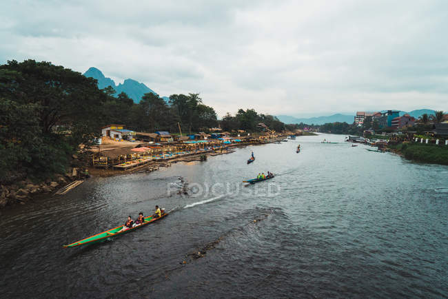 Blick auf fließenden Fluss und lange Boote, die in tropischer Natur segeln. — Stockfoto