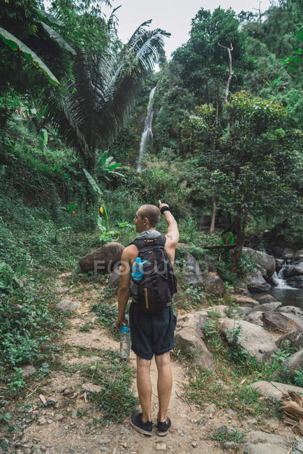 Rer vista de turista apontando para cascata — Fotografia de Stock