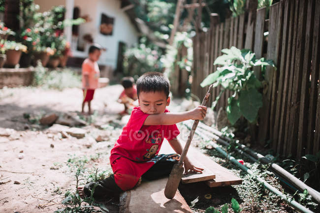 Laos, luang prabang: kleines Kind mit Stock auf der Straße — Stockfoto