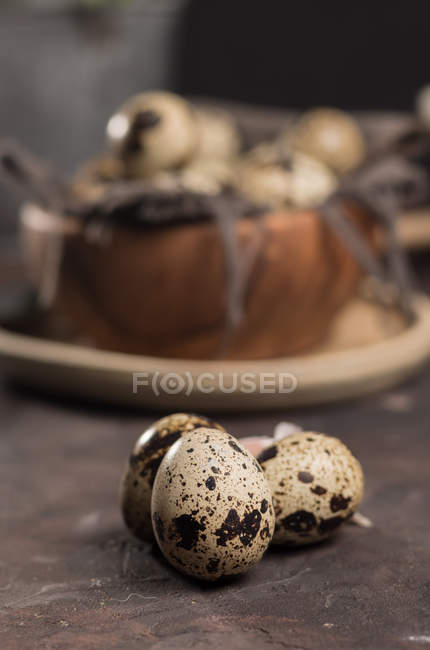 Close up view of eggs of quail by wooden bowl. — Stock Photo