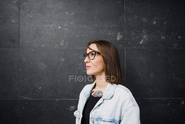 Brünette Frau in Brille posiert auf grau — Stockfoto