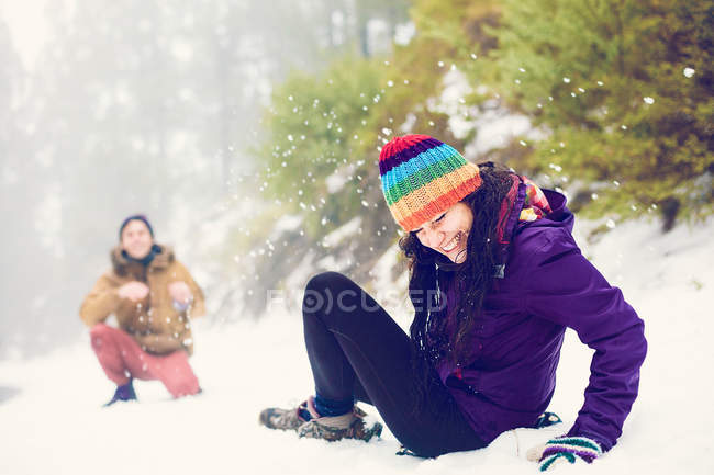 Amici felici giocando palle di neve nei boschi — Foto stock