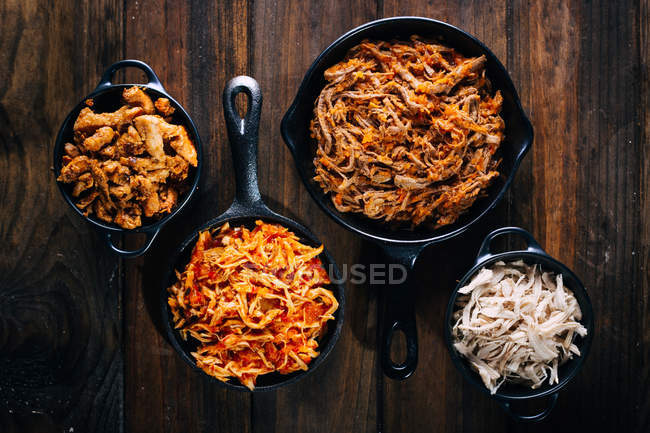 Зверху асортимент апетитних страв у сковороді на дерев'яному столі . — стокове фото