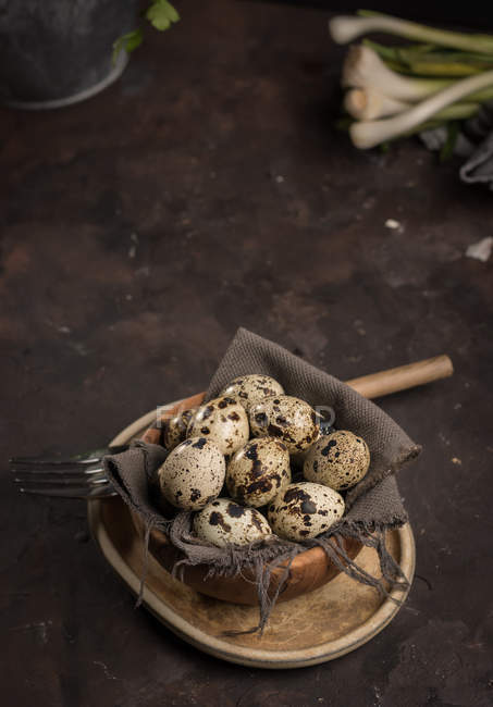 Still life of eggs of quail in wooden bowl on table — Stock Photo