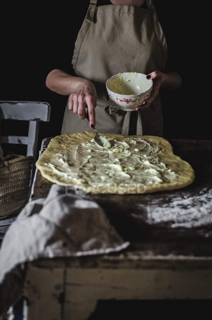 Средняя часть женщины кладет начинку на тесто во время приготовления пищи . — стоковое фото