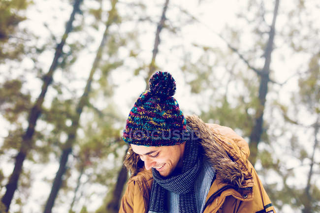 Веселый мужчина в зимней одежде в лесу — стоковое фото