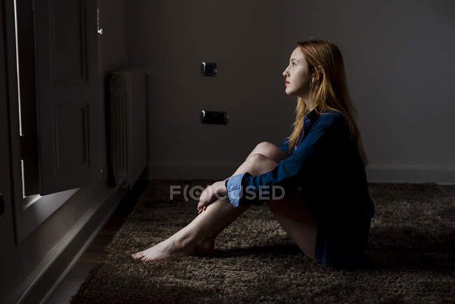 Side view of blonde woman posing on floor — Stock Photo