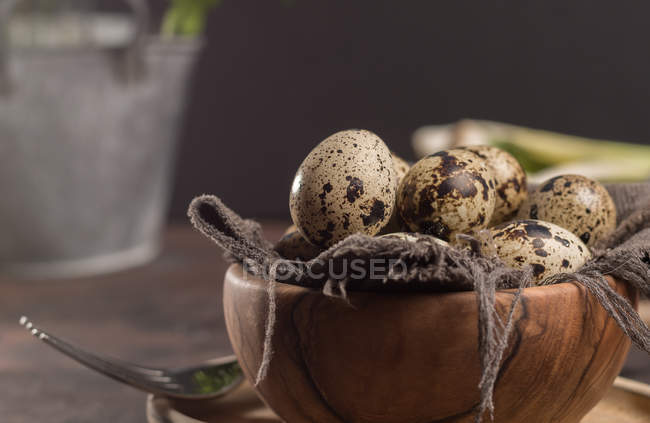 Vista de cerca de los huevos de codorniz en tazón de madera - foto de stock