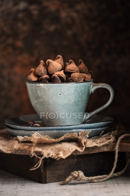 Chocolate truffles in rustic ceramic cup — Stock Photo