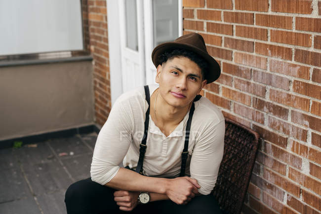 Dreamy stylish man in vintage clothes posing on balcony — Stock Photo