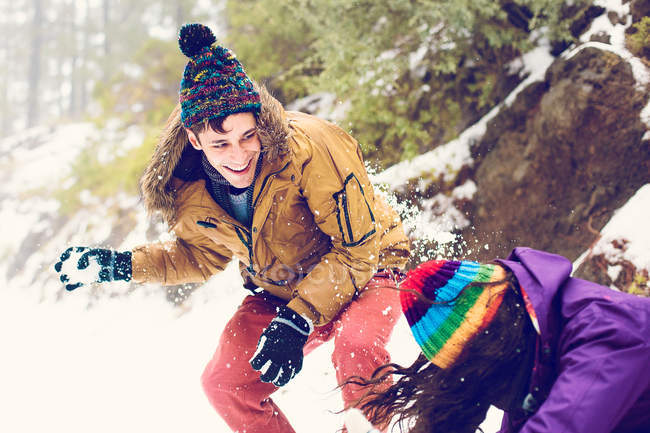 Amici felici giocando palle di neve nei boschi — Foto stock