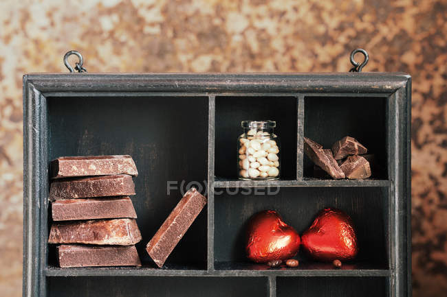 Scatola rustica in legno con vari cioccolatini sugli scaffali — Foto stock