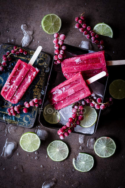 Still life of popsicle with berries and lime slices — Stock Photo