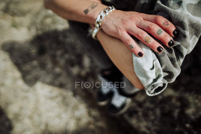 Mão tatuada fêmea da colheita com mangas roladas — Fotografia de Stock