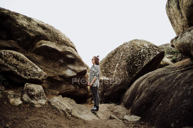 Side view of woman in glasses posing at stones — Stock Photo