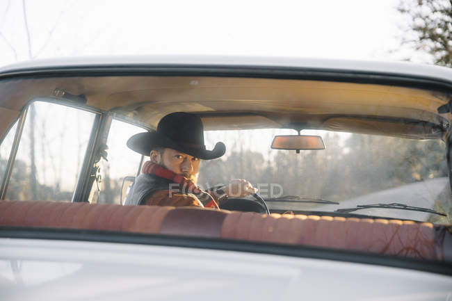 Homem barbudo em chapéu carro de condução traseira — Fotografia de Stock