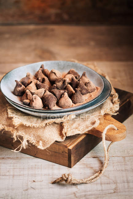 Bodegón de trufas de chocolate en plato rústico de cerámica sobre mesa - foto de stock