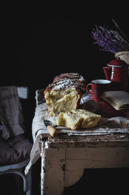 Bodegón de pastel dulce cubierto de azúcar en polvo sobre mesa rústica . - foto de stock