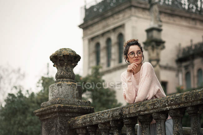 Femme pensive en verre appuyée sur une main courante ornée sur la terrasse — Photo de stock