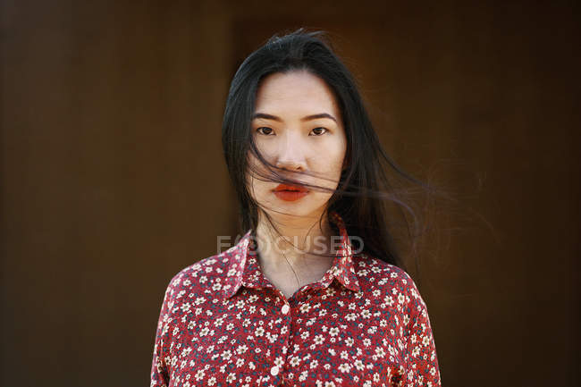 Ritratto di donna serena con capelli ventosi che guarda la macchina fotografica — Foto stock